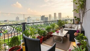 A balcony with outdoor seating, potted plants, and a city view. - FabHotel Sapphire 83 Best hotel in Manesar, Gurugram (Gurugram)