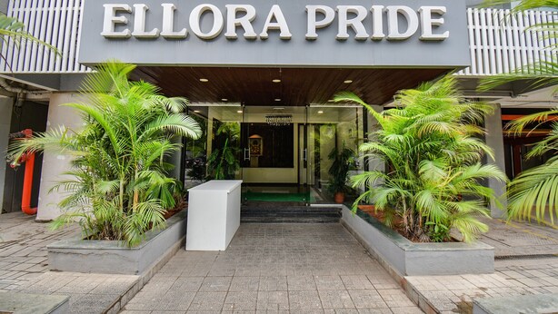 The exterior of a hotel named 'Ellora Pride' with a modern design, featuring a prominent entrance and potted plants. - Fabhotel Gargi Inn (Pune)