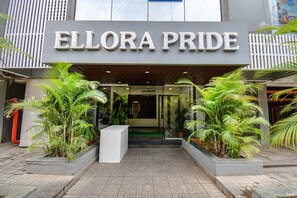 The exterior of a hotel named 'Ellora Pride' with a modern design, featuring a prominent entrance and potted plants. - FabHotel Gargi Inn - Nr. Balewadi Stadium (Pune)