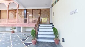 A staircase leading to a building entrance with a tiled floor and potted plants. - FabHotel JBS Heritage (Jaipur)
