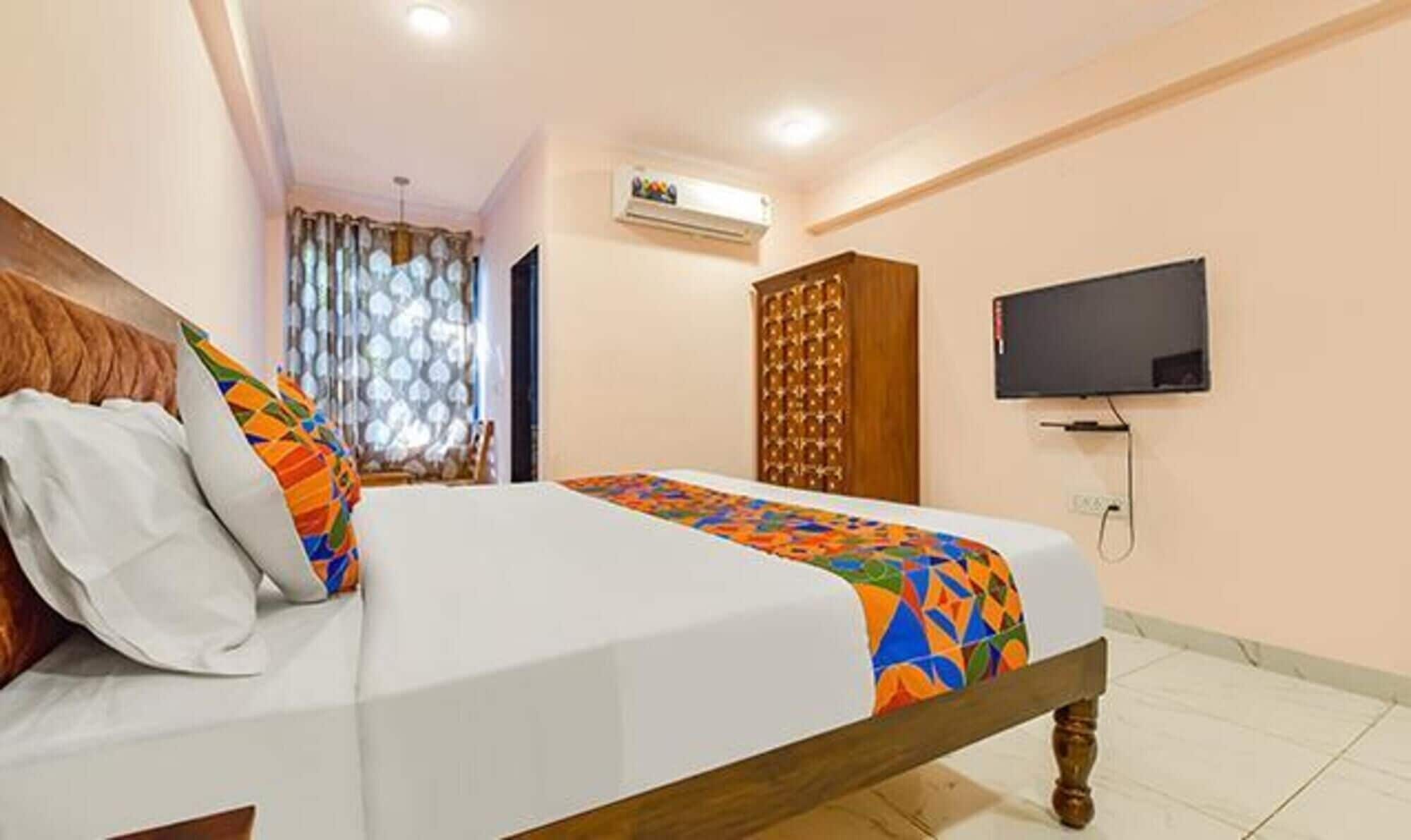 Ein Hotelzimmer mit Bett, Fernseher, Klimaanlage und Kleiderschrank.