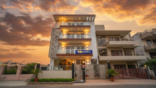 A multi-story hotel with a modern facade, a prominent 'fabHOTELS' sign, and a gated entrance. - Fabhotel Emoji Stays (Gurugram)