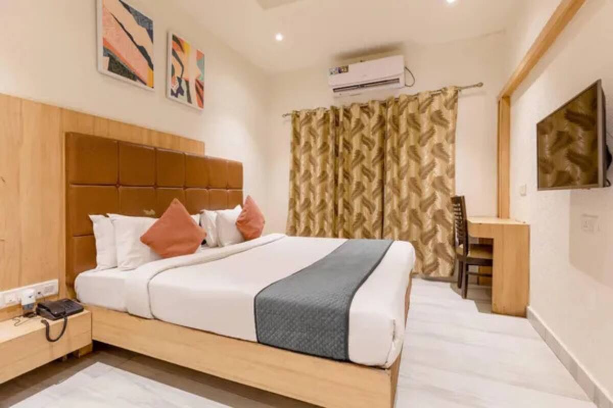 Ein modernes Hotelzimmer mit einem großen Bett, einem Schreibtisch und einer Klimaanlage.
