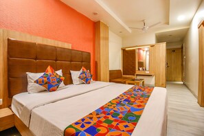 Relax in a stylish room with a large bed, geometric-patterned pillows and bed runner, and a wooden nightstand with a lamp.