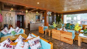 A cozy hotel lobby with wooden furniture, a reception desk, and decorative plants. - FabHotel Winterline Inn (Dehradun)