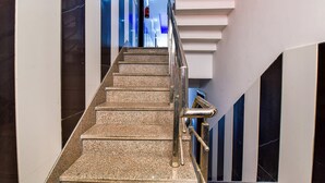 Un escalier doté d’une rampe métallique, de murs en marbre et d’un design moderne.
