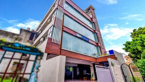 Un hôtel moderne, reconnaissable à son grand panneau « tob hotels », à ses larges fenêtres et à sa structure à deux étages.