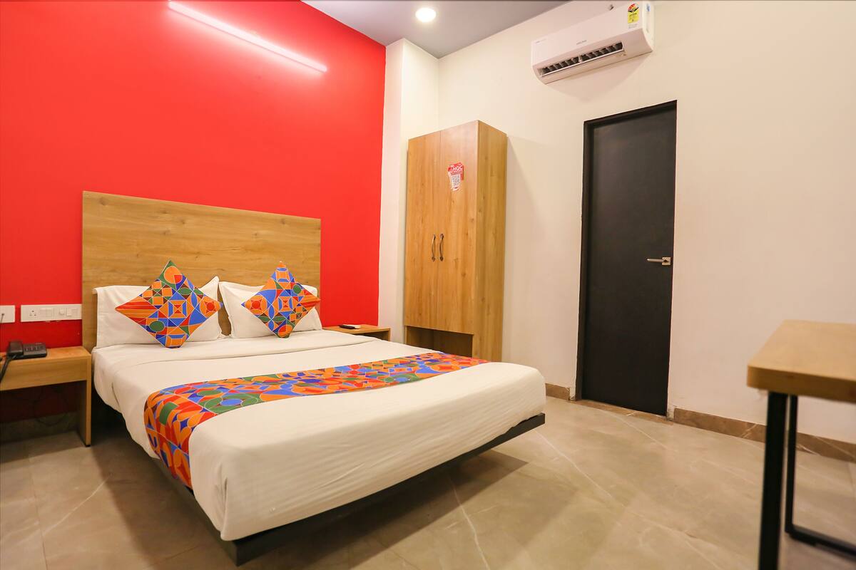 Une chambre d’hôtel avec un lit, une armoire, un bureau et une porte.
