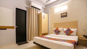 Een hotelkamer met een bed, een kledingkast, een deur en een airconditioning.