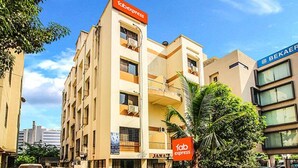 A multi-story building with 'Tab Express' signage, indicating a hotel or similar establishment. - FabHotel East Field Homes (Pune)