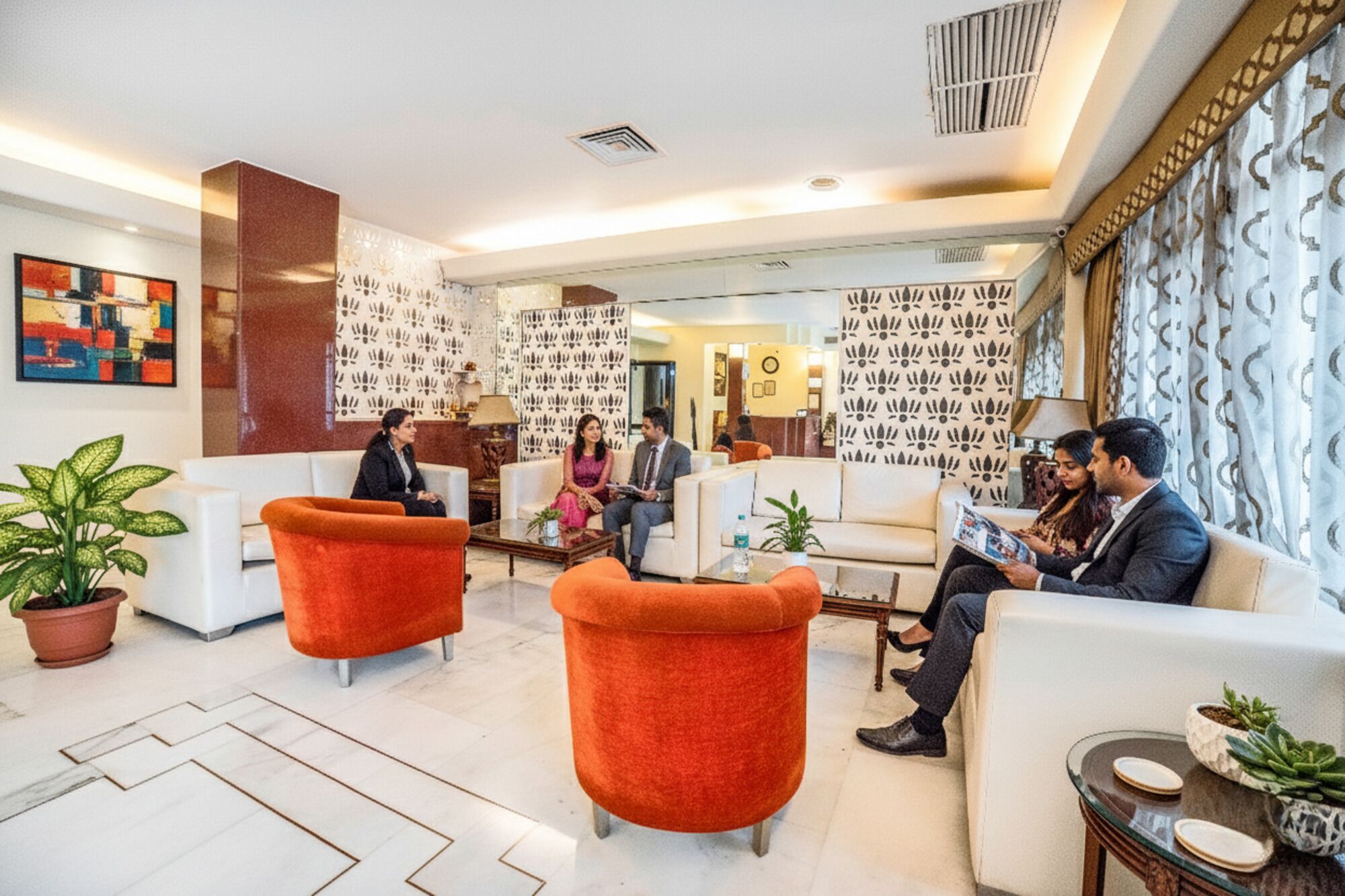 A modern lobby with seating areas, a reception desk, and decorative wall panels.