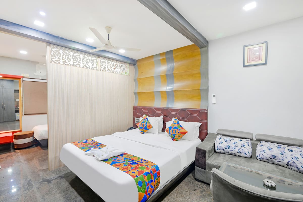 Ein Hotelzimmer mit Bett, Sofa, Deckenventilator und einer dekorativen Wandverkleidung.