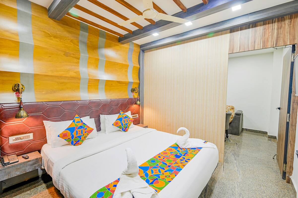 Ein Hotelzimmer mit einem großen Bett, einem Kopfteil mit geometrischem Muster und einer Wand mit Streifenmuster.