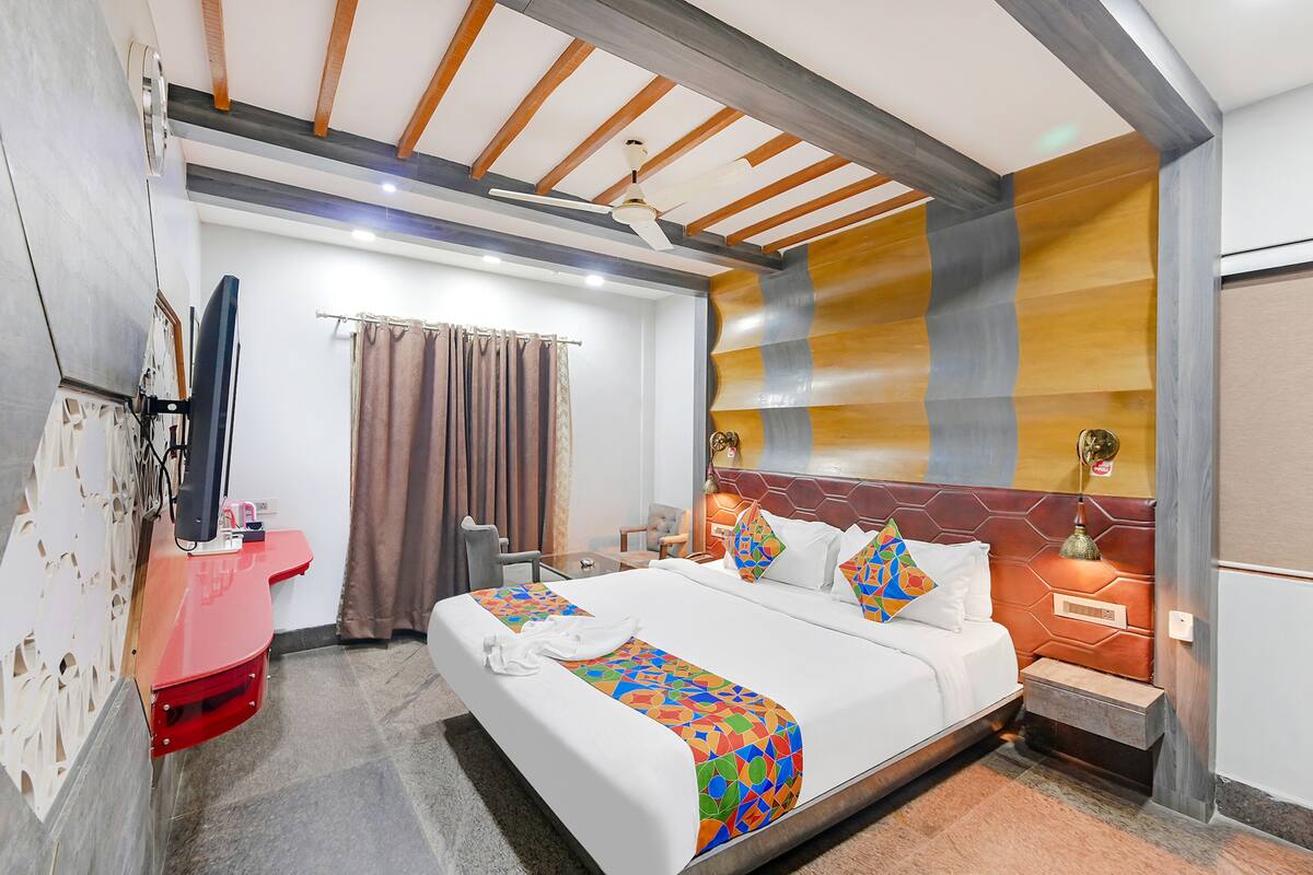 Ein Hotelzimmer mit Bett, Nachttisch, Fernseher und Waschbecken in Rot.