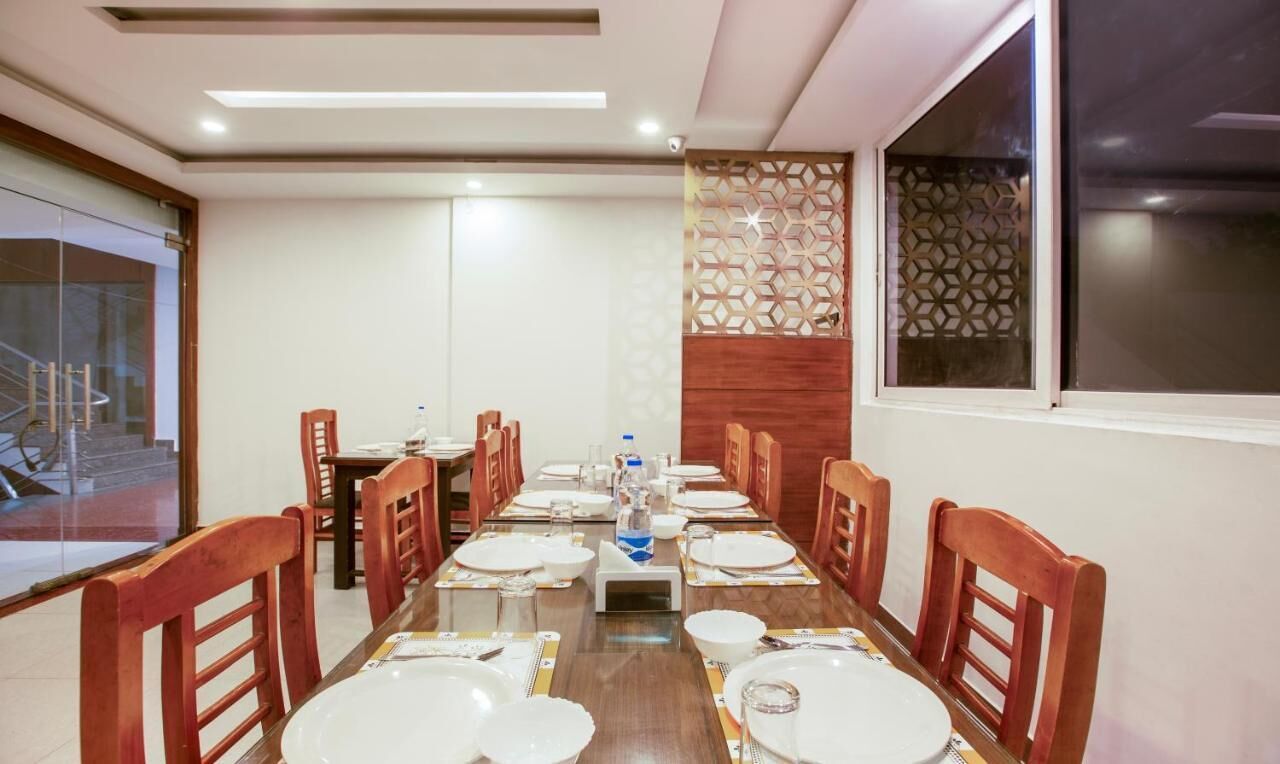 A conference room with a long table set for a meeting, equipped with chairs, plates, and water bottles.