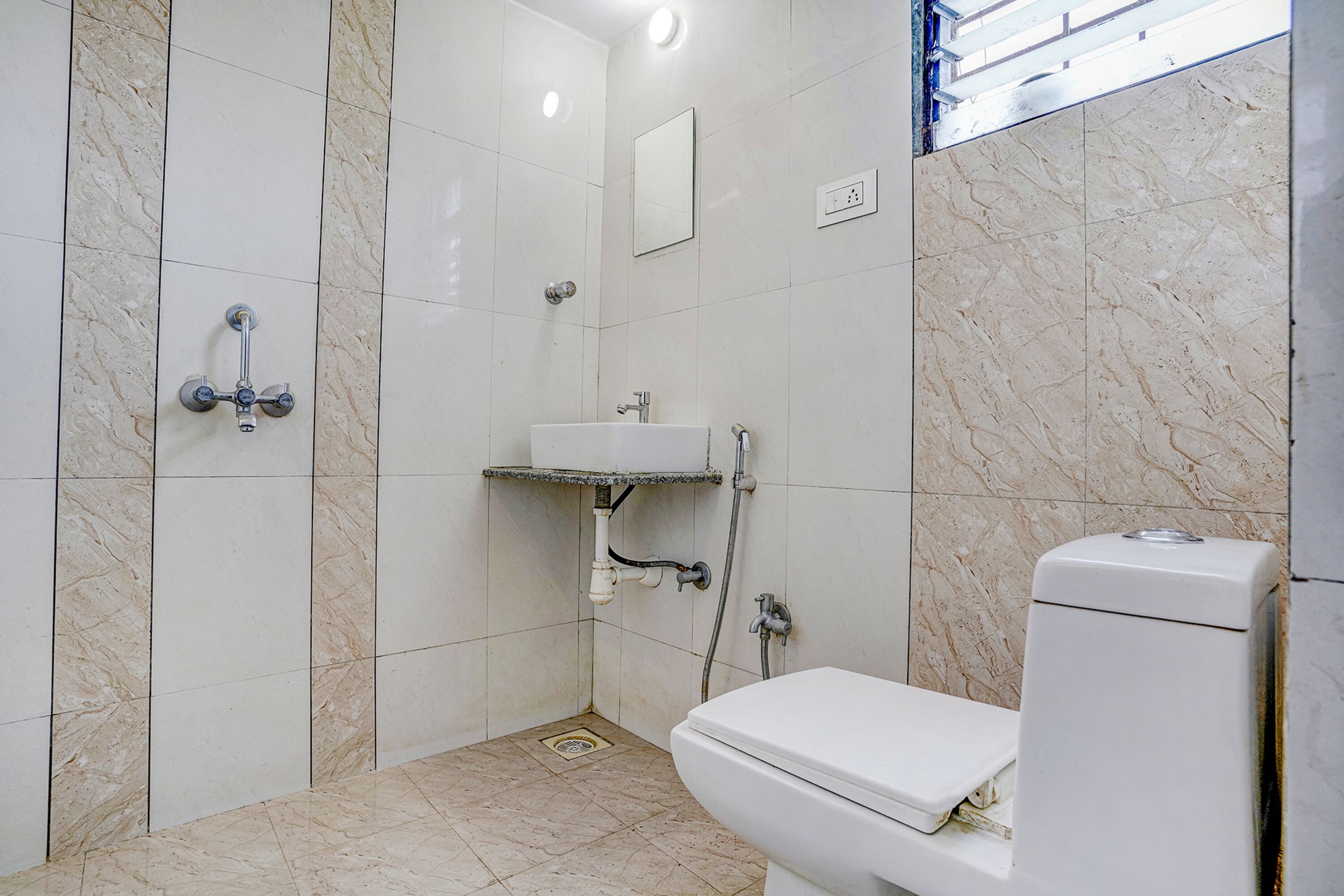 A bathroom with a toilet, sink, and shower.