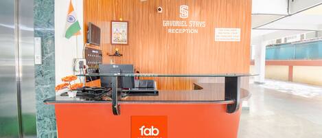 Un mostrador de recepción con panel de madera y un cartel que dice 'Gavriel Stays Reception'.