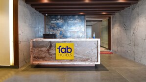 Ein Empfangsschalter mit Marmorplatte und einem Schild mit der Aufschrift 'fab hotels'.