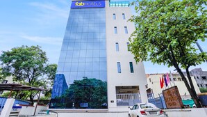 A tall hotel building with a modern glass facade and a sign reading "FabHotels". - Fabhotel Crystal Homes (Pune)