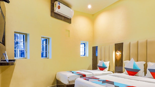 A hotel room with two beds, a desk, and an air conditioning unit. - Fabexpress Gateway Inn (Mumbai)