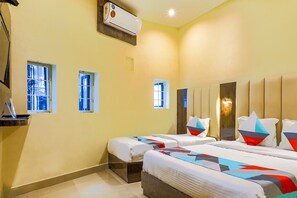 A hotel room with two beds, a desk, and an air conditioning unit. - Fabexpress Gateway Inn (Mumbai)