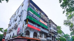 A multi-story building with various commercial spaces on the ground floor, including a shop with a sign that reads "Equi Mart". - Fabexpress Gateway Inn (Mumbai)