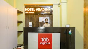 A hotel reception desk with a sign for HOTEL ABAD INN and a FAB EXPRESS logo. - Fabexpress Gateway Inn (Mumbai)