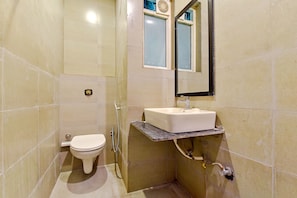 Un baño pequeño con inodoro, lavamanos y espejo.