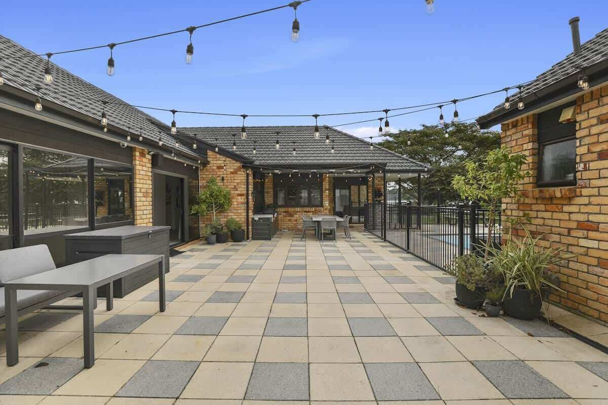 A patio with outdoor seating, a brick wall, and string lights.