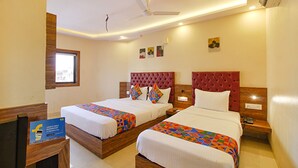 A hotel room with two beds, a window, and a ceiling fan. - FabHotel Peninsula (Mumbai)