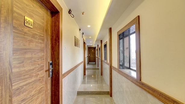 A hallway with wooden doors, numbered 501, and a window on the right. - FabHotel Peninsula (Mumbai)