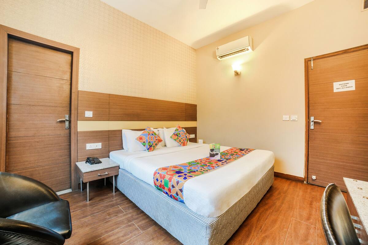 Ein Hotelzimmer mit Bett, Nachttisch, Stuhl und Tür.