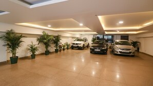 A spacious indoor parking area with multiple cars parked.