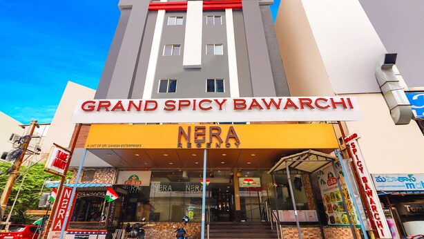 A hotel named "Grand Spicy Bawarchi" with a prominent sign and a "Nera Regency" sign below. - Fabhotel Nera Regency (Hyderabad)