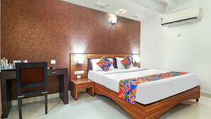 A hotel room with a wooden bed, a desk, and a chair. - Fabhotel Nera Regency (Hyderabad)