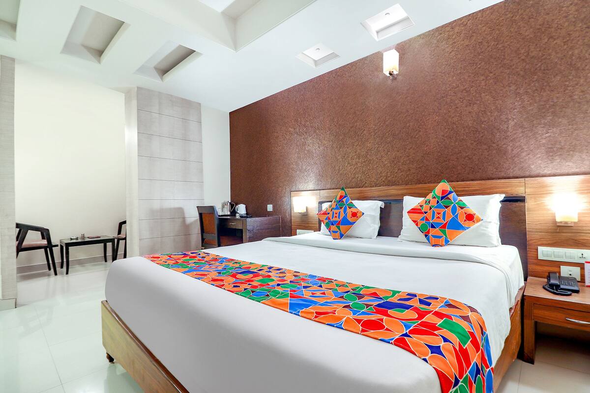 Quarto de hotel com uma cama grande, uma mesa e uma cadeira.