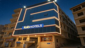 A building with a sign reading "fabHOTELS" and a modern design with illuminated lines. - FabHotel The Golf Inn - Nr Botanical Garden Metro (Noida)