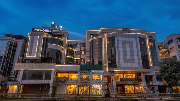 A modern hotel with a prominent 'fabHOTELS' sign, multiple floors, and illuminated storefronts. - Fabhotel Skyland (Ahmedabad)