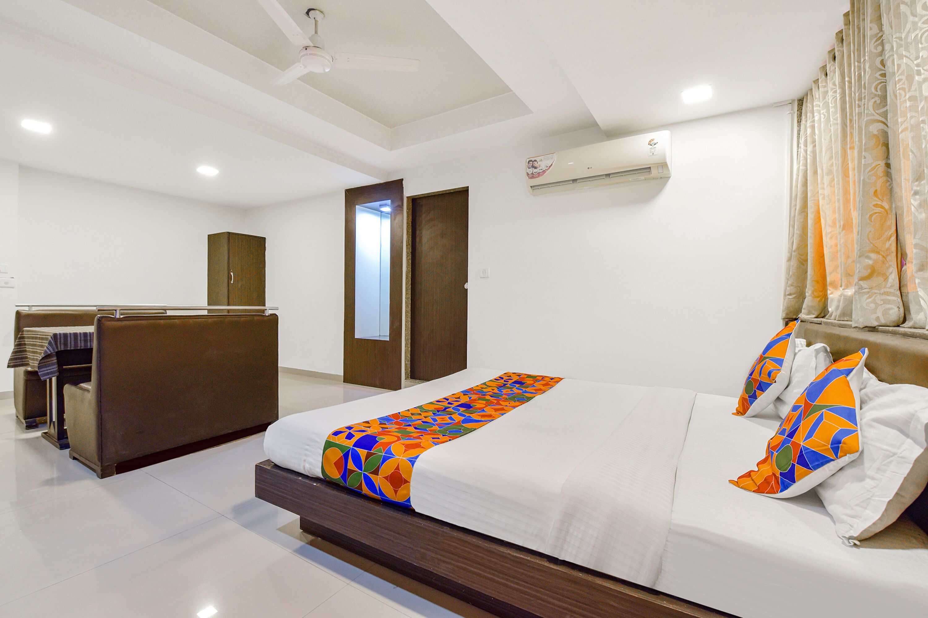 Ein Hotelzimmer mit Bett, Kleiderschrank, Schreibtisch und Klimaanlage.