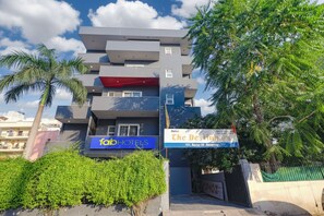 A modern hotel building with a blue sign for 'fab hotels' and another sign for 'The Desilvers' hotel. - Fabhotel Destiny Inn (Gurugram)