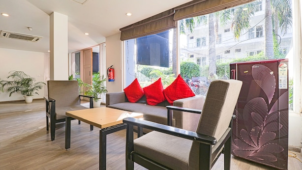 A modern hotel room with a sofa, armchairs, a small table, and a large window offering a view of the city. - Fabhotel Destiny Inn (Gurugram)