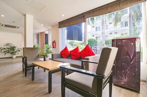 A modern hotel room with a sofa, armchairs, a small table, and a large window offering a view of the city. - Fabhotel Destiny Inn (Gurugram)