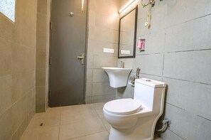 A bathroom with a toilet, sink, and mirror. - Fabhotel Destiny Inn (Gurugram)