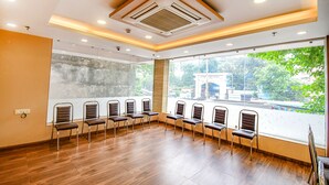 A conference room with wooden flooring, a large window with a view of greenery, and a ceiling with recessed lighting. - Fabhotel Stay Inn International (Kolkata)