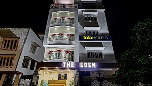 A hotel named "The Eden" with a signboard, balconies with red flowers, and a "fabHOTELS" logo. - Fabhotel The Eden Ruby (Kolkata)