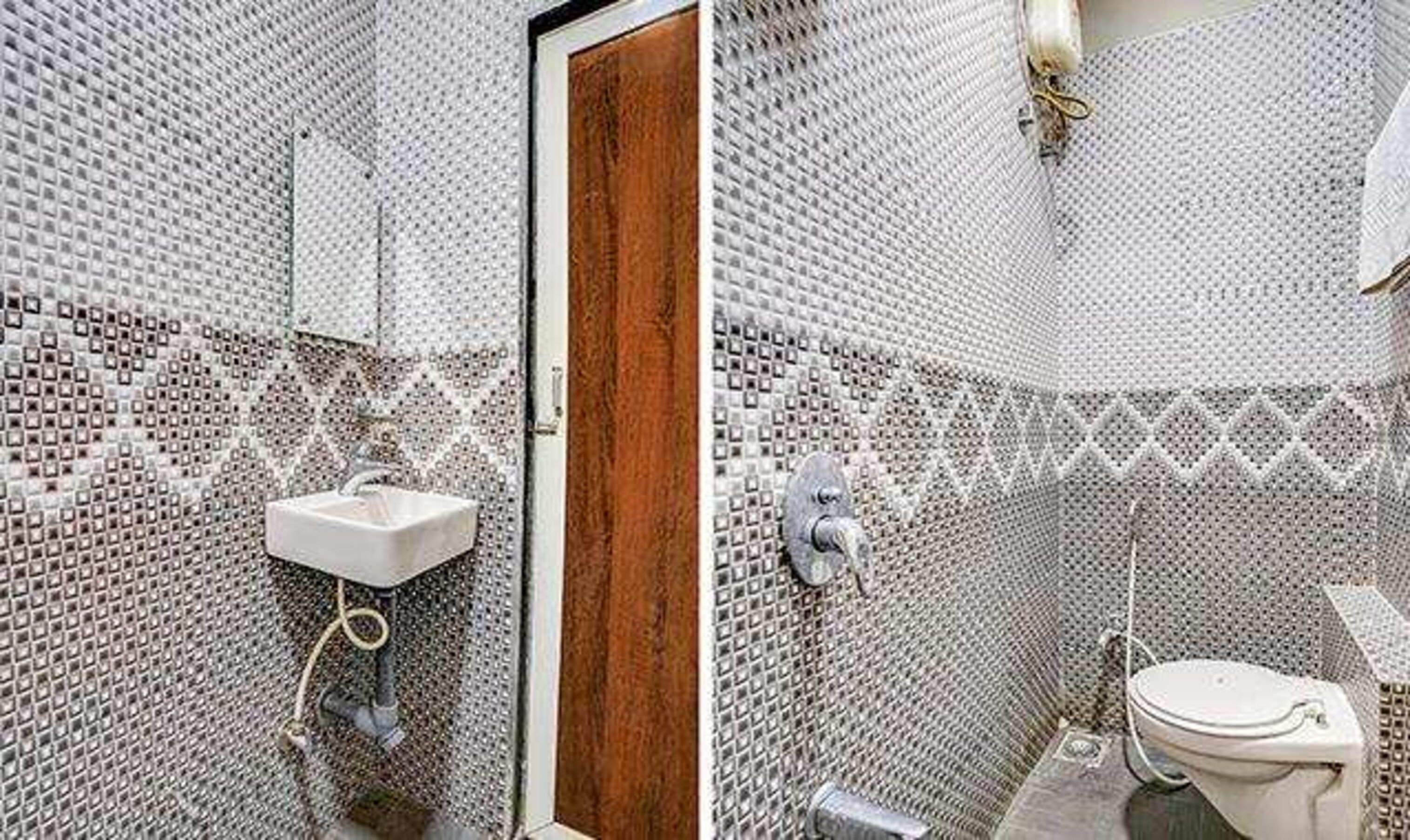 A bathroom with a sink, mirror, and toilet, all set against a wall of small, square tiles.