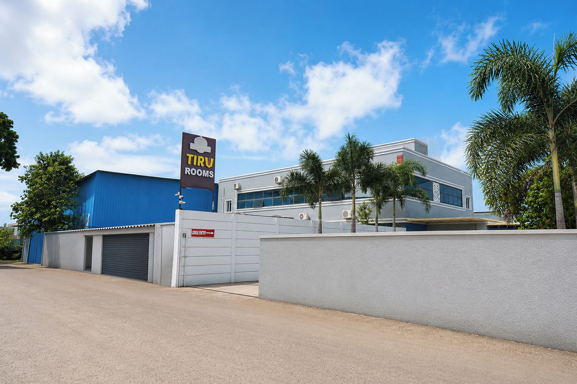A modern building with a sign for 'TIRU ROOMS' and a 'LODGUE ENTRY' sign.