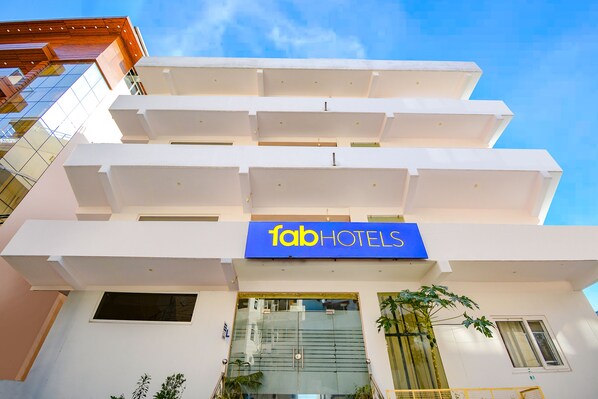 A multi-story building with a 'fab hotels' sign, large windows, and a modern architectural design.