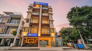 A multi-story hotel with a 'fabHOTELS' sign, featuring a modern design with balconies and a gated entrance. - Fabhotel Kings Suites (Bengaluru)