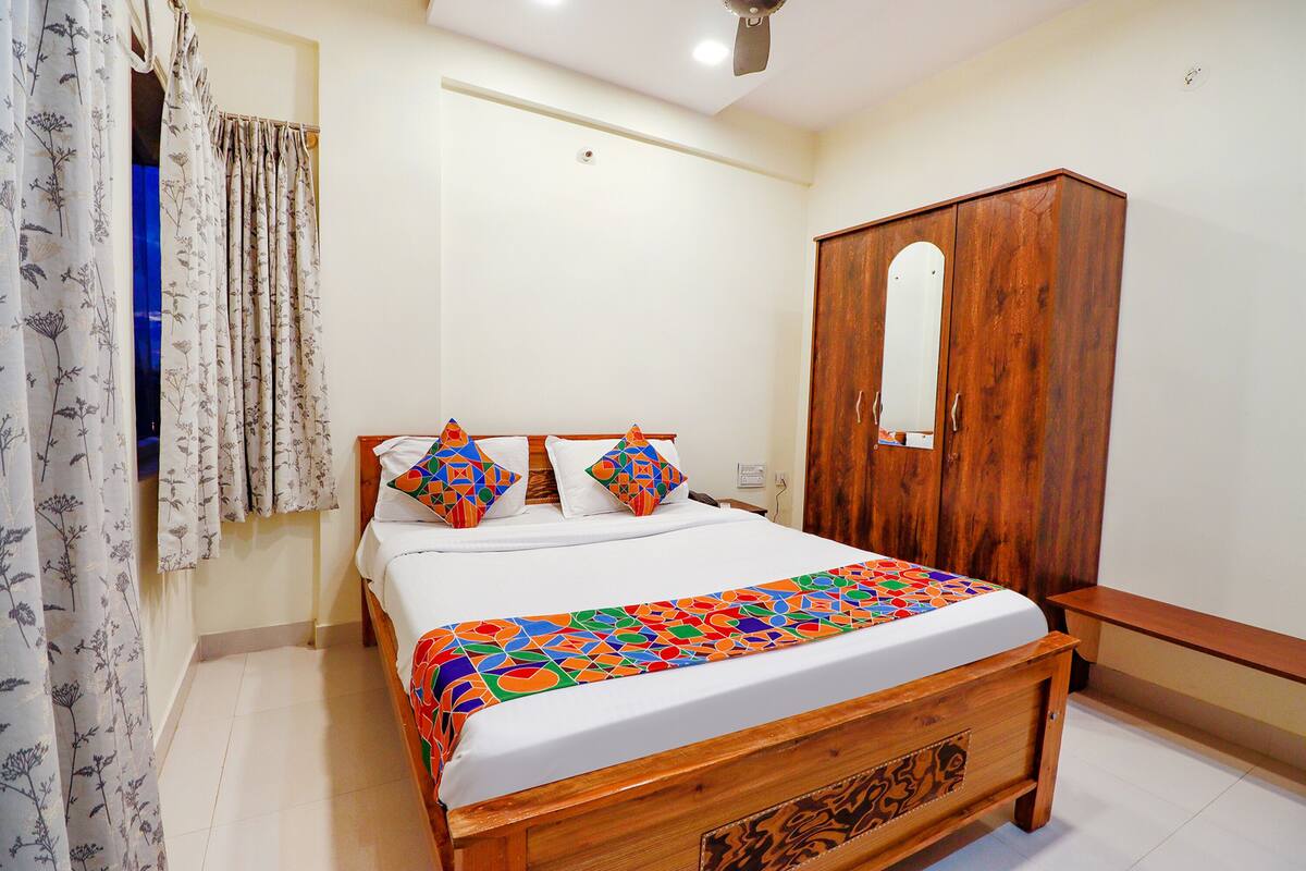 A bedroom with a wooden bed, a wardrobe, and a mirror.